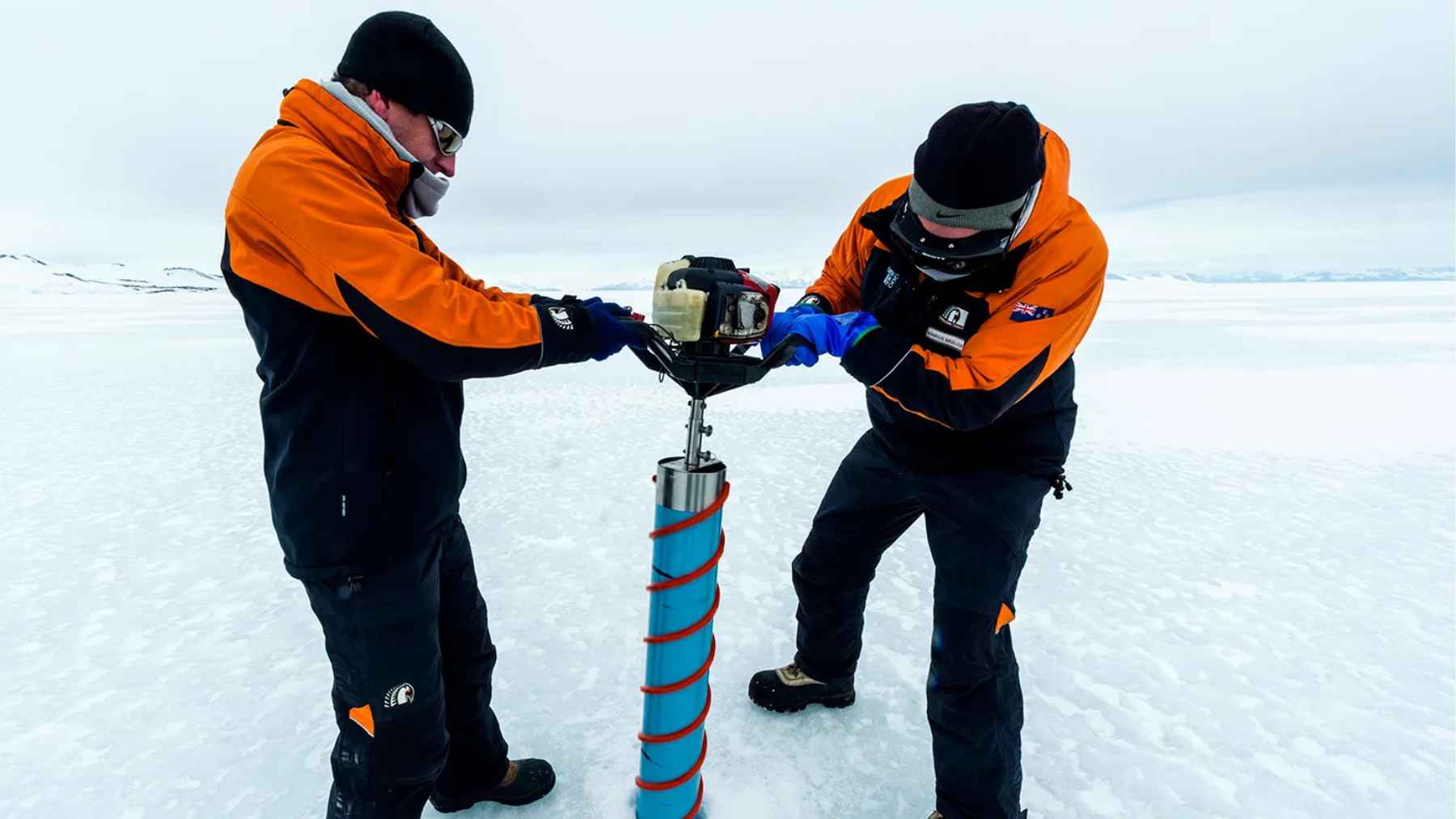 Scientists drilling an ice core sample on the Antarctic ice sheet to collect climate data for long term research.