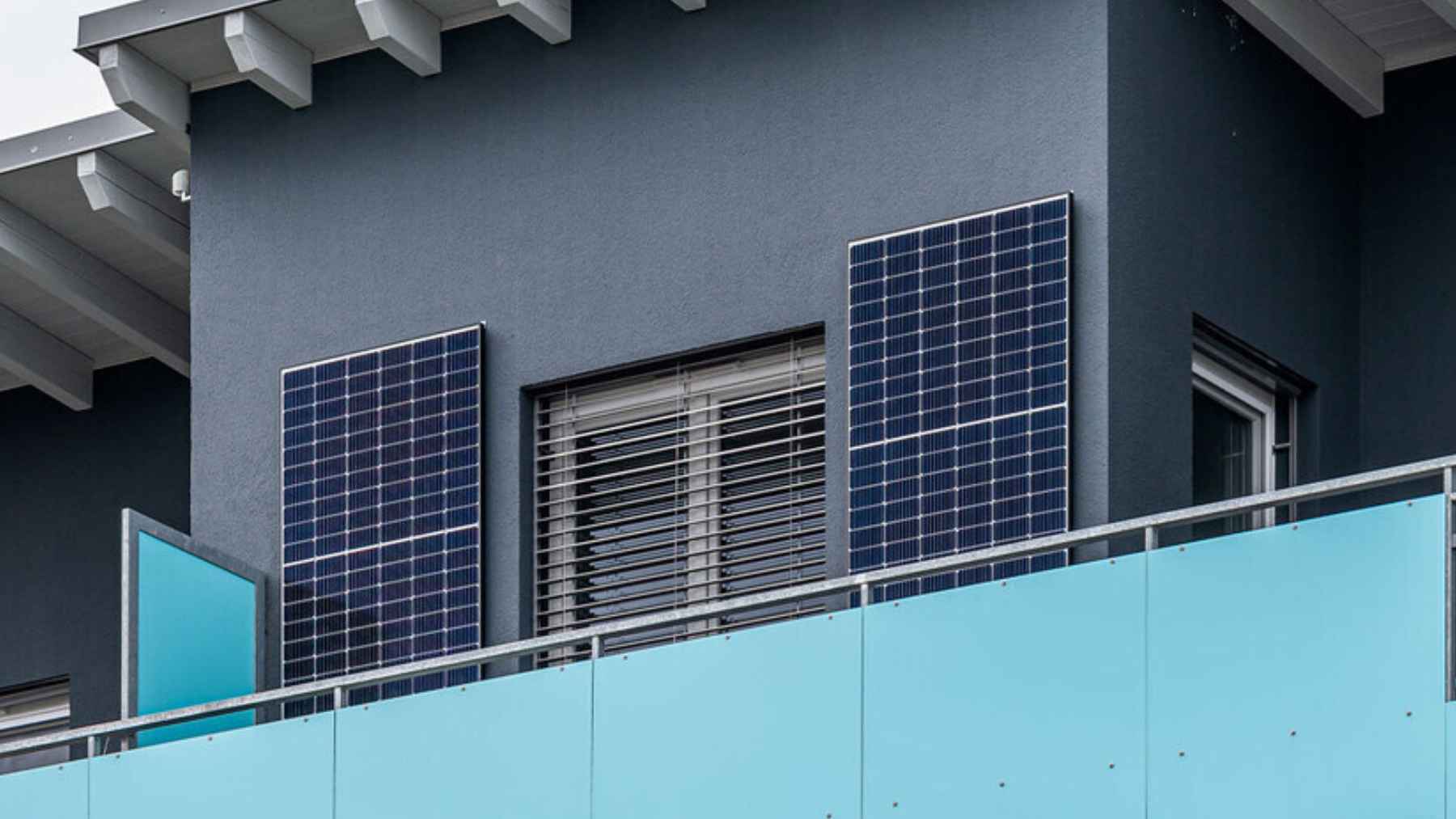 Small solar panels installed on an apartment balcony railing as part of a home energy setup.