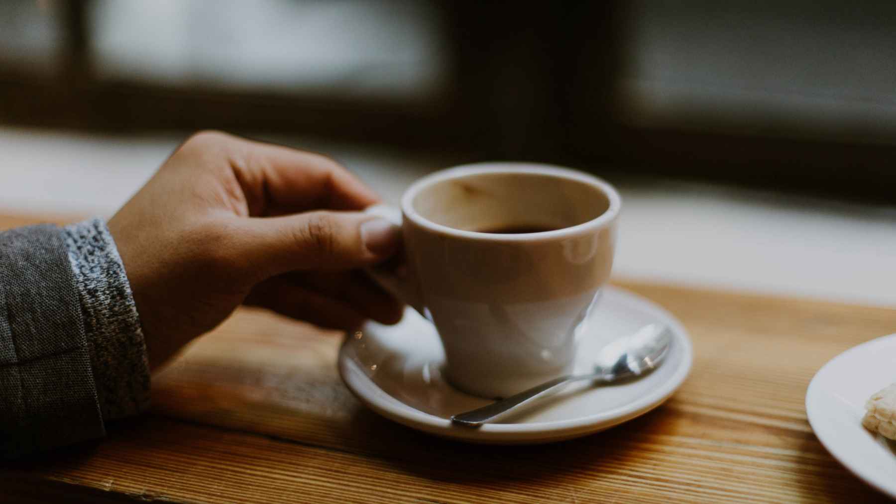 Morning cup of coffee on a kitchen table illustrating the recommended timing for caffeine after waking up.