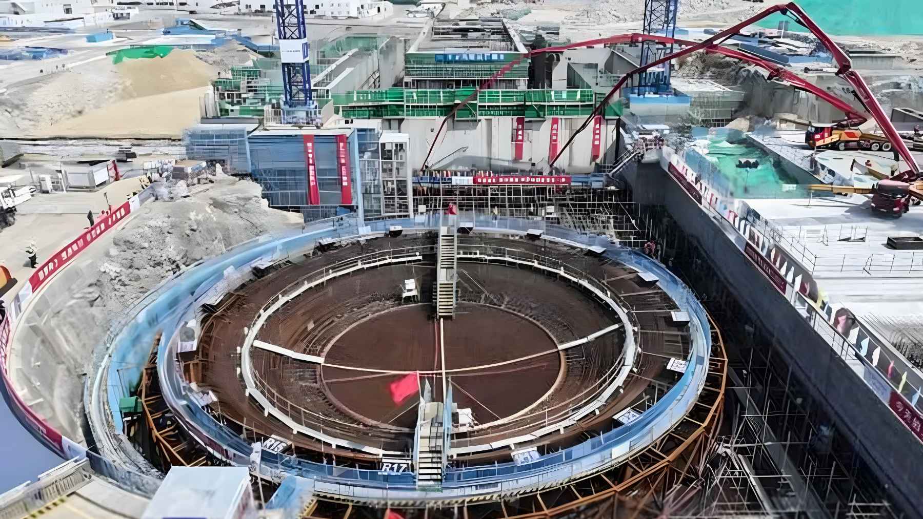 Aerial view of a nuclear power plant construction site in China with circular reactor structure and heavy machinery