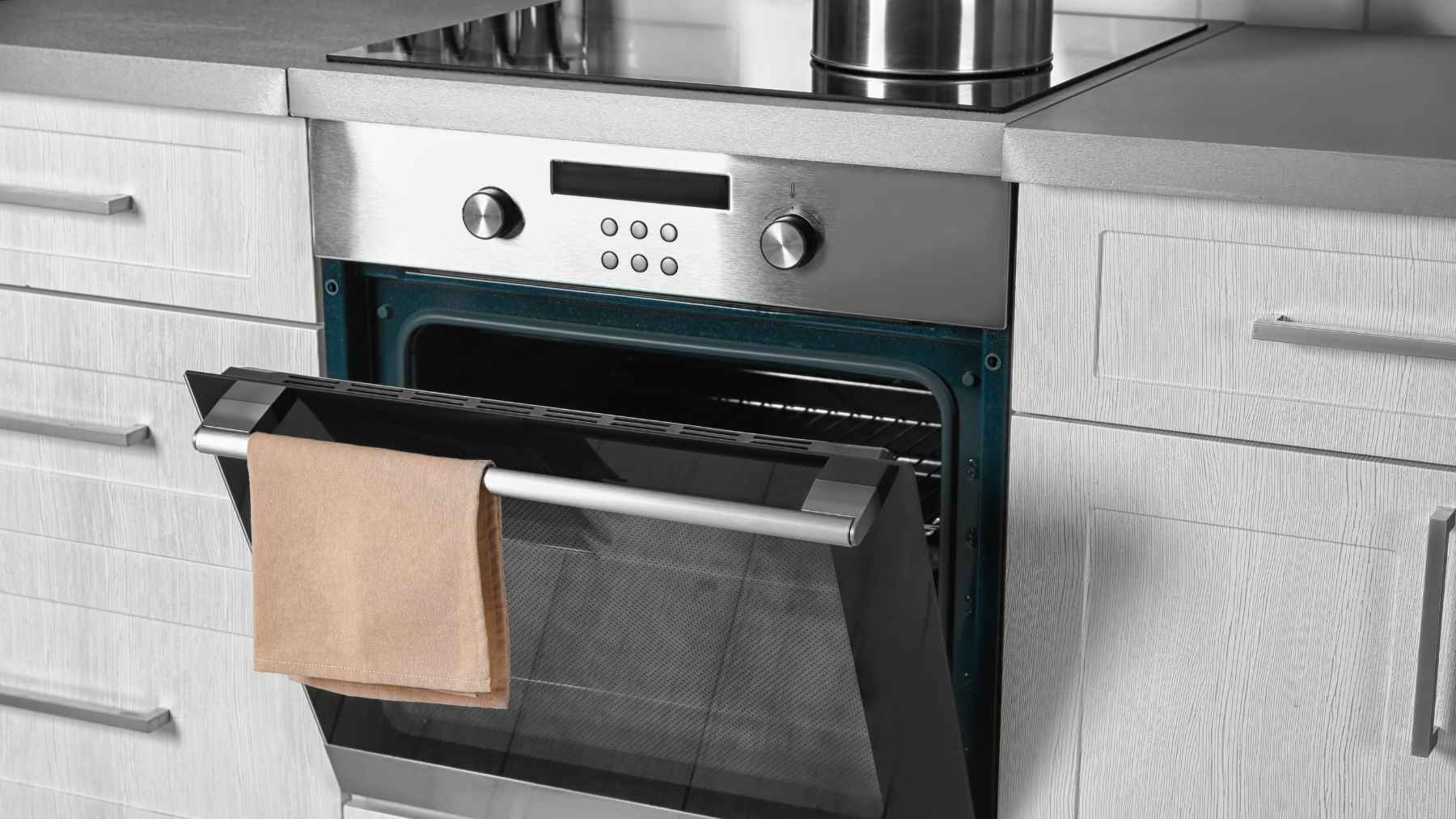 One appliance in the average kitchen can briefly consume as much electricity as 65 refrigerators, and that surprising spike is forcing a closer look at how homes waste power every single week 1 Modern electric oven with open door in kitchen, illustrating high power use during preheating