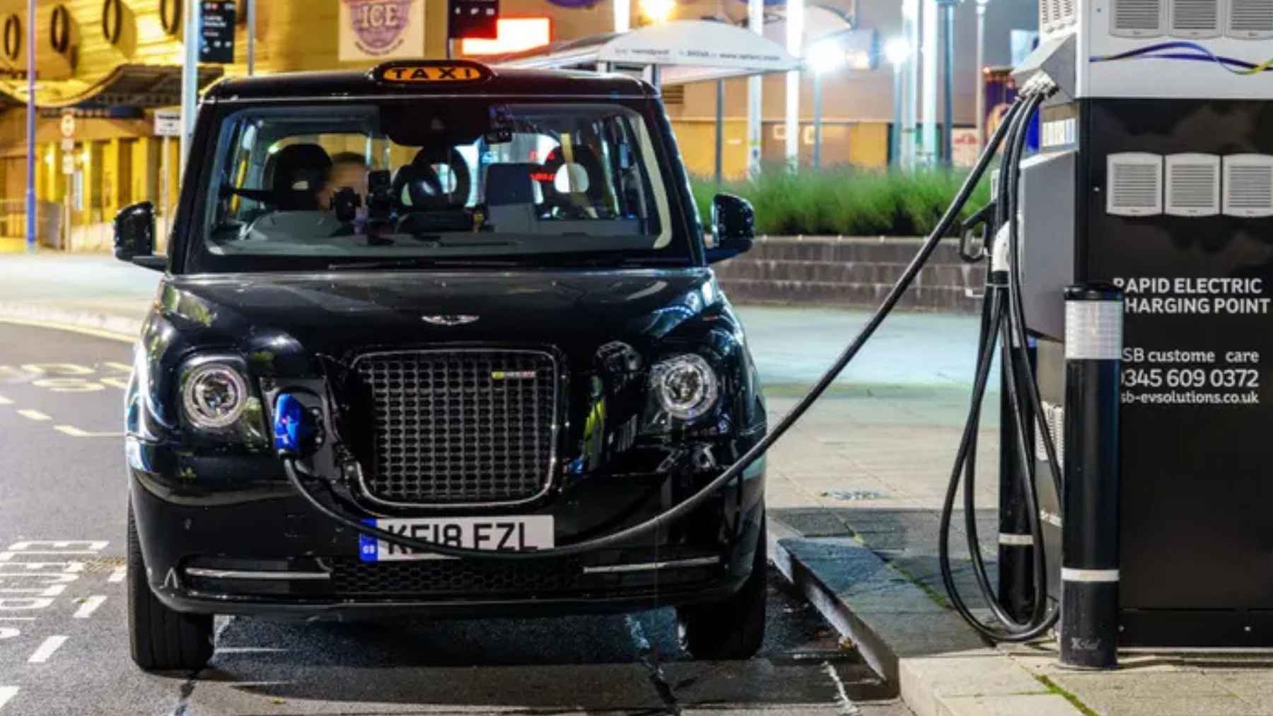 Electric vehicles charging at a station highlighting global EV demand slowdown and declining sales trends in key markets