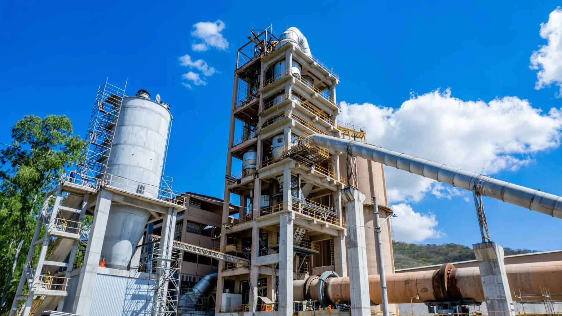 Cement production plant with industrial towers and kilns representing global construction materials industry