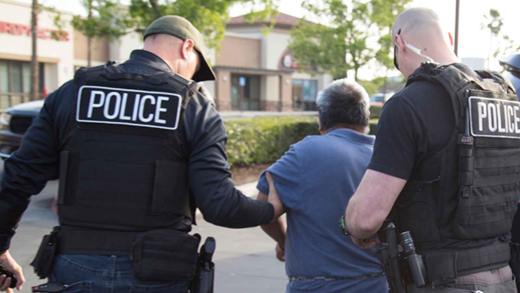 Federal immigration officers detain a man during an enforcement operation linked to Operation Country Roads.
