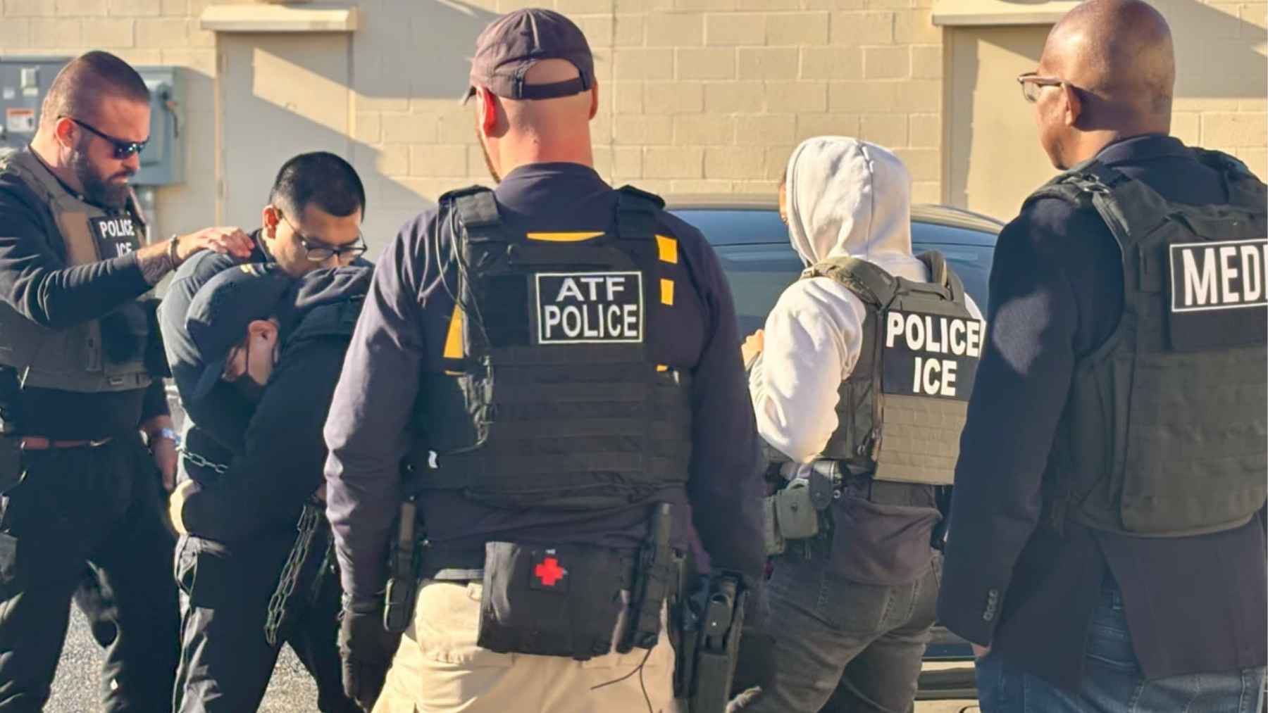 Masked ICE agents detaining a person during an immigration enforcement operation in West Virginia.