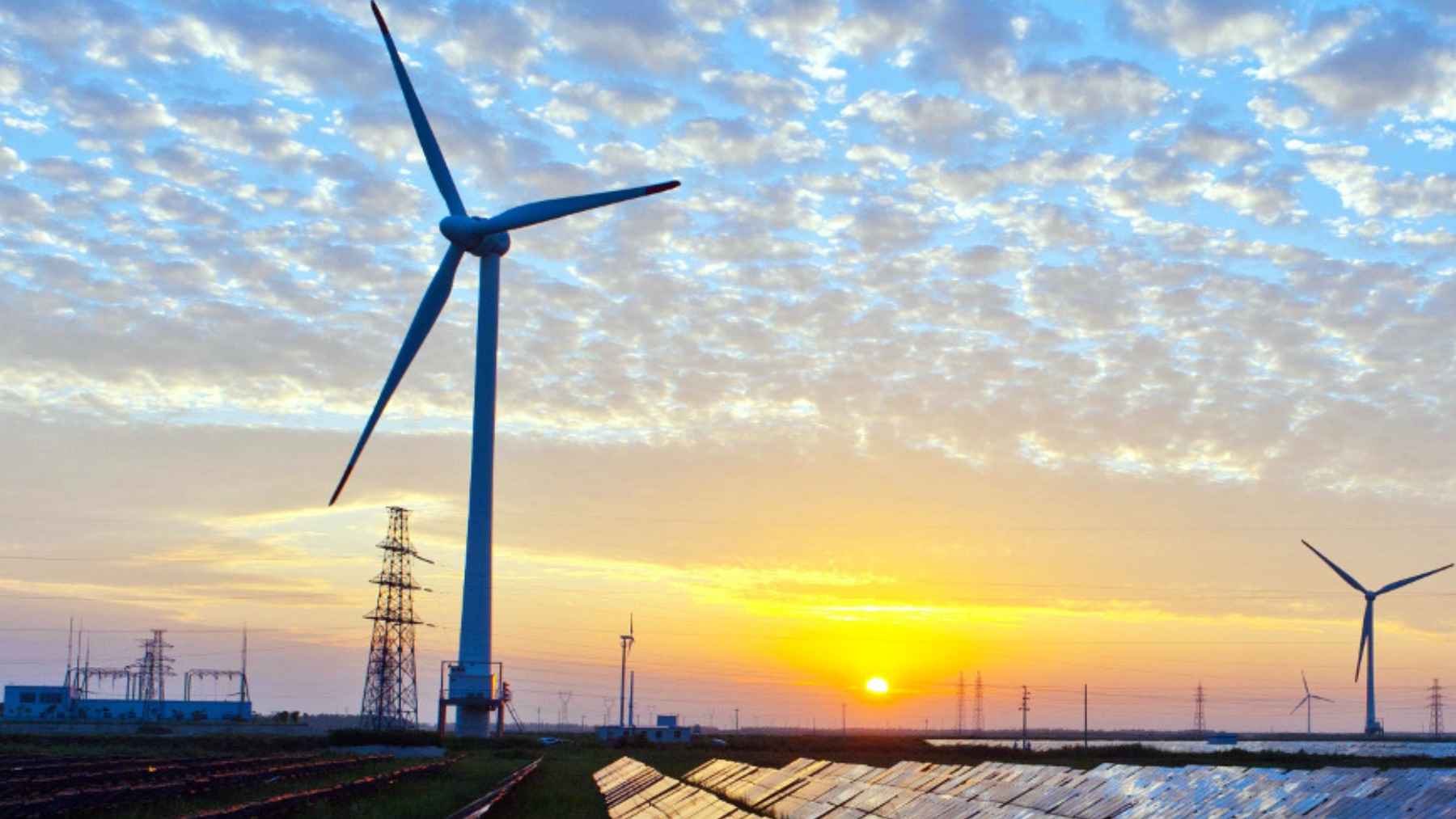 The IMF warns that high energy prices could push inflation higher and weaken global growth, and the world economy may be less prepared than it wants to admit 1 Wind turbines and solar panels at sunset representing global energy markets and rising prices impacting inflation