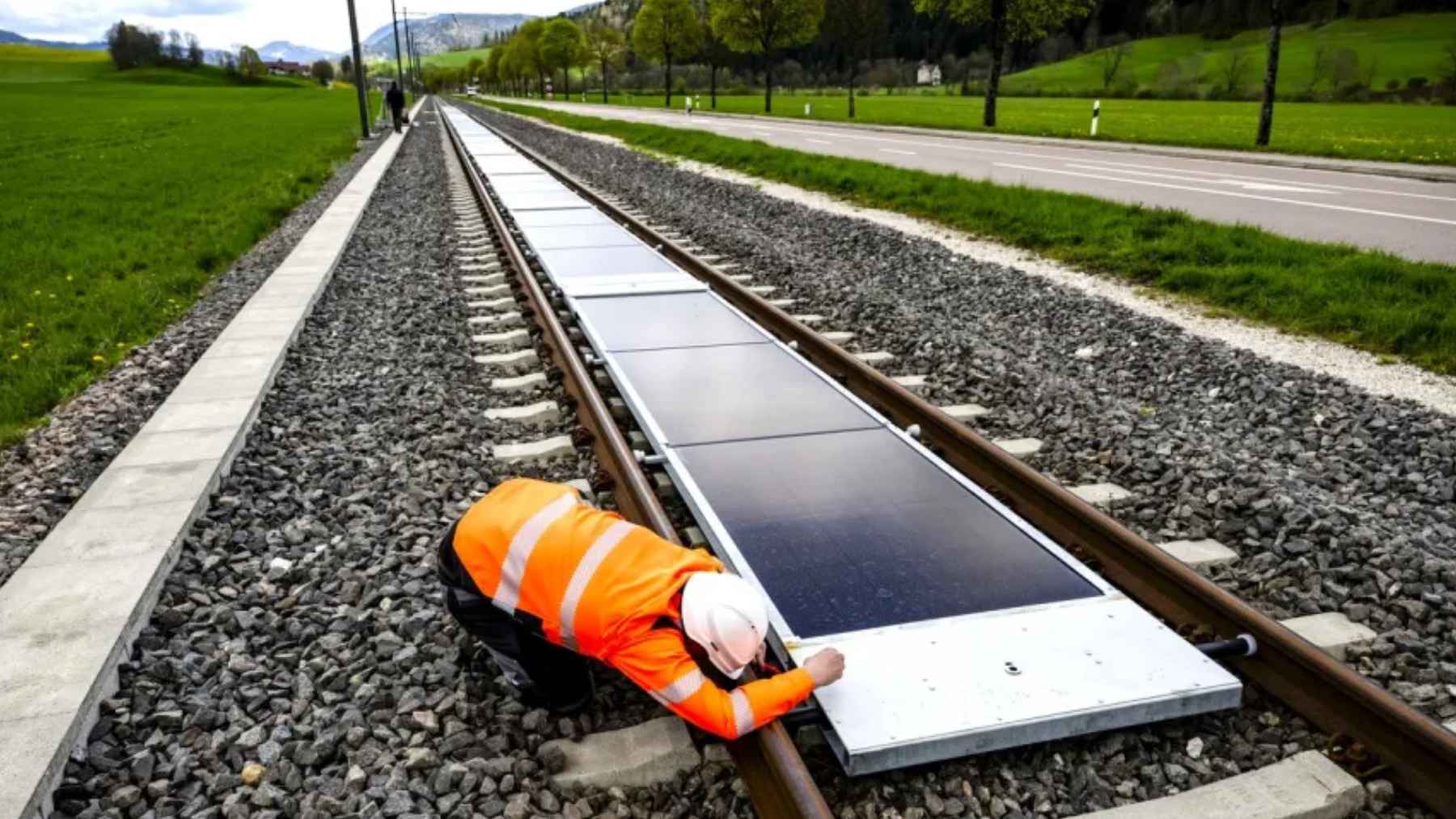 Solar panels installed between railway tracks as part of a removable solar energy system for active rail lines.