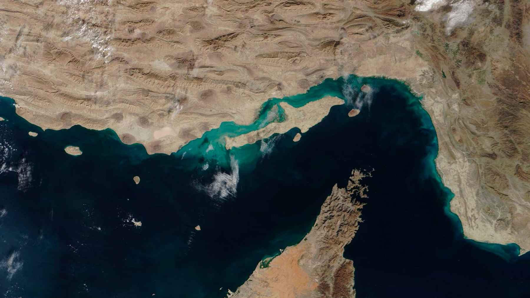 Oil tankers navigating the Strait of Hormuz under heightened naval tensions and restricted passage conditions