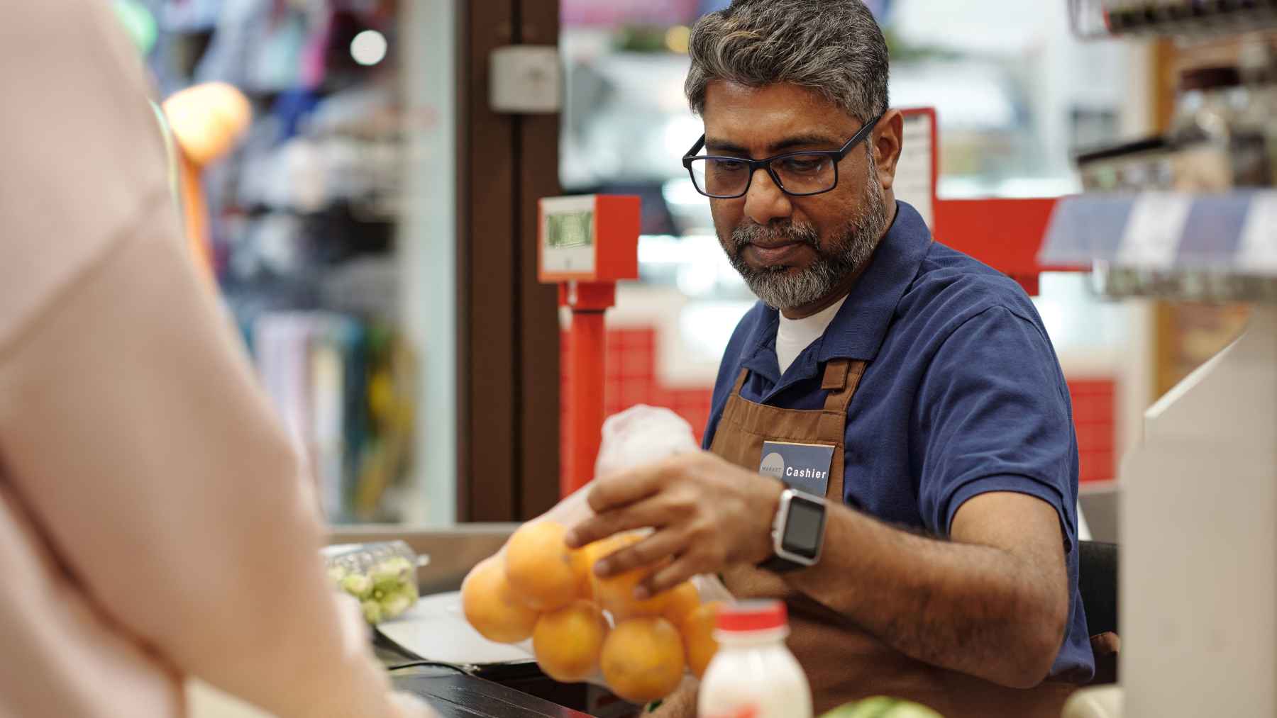 Cashier helping a customer at a checkout counter, illustrating Target’s new in-store customer service rule.