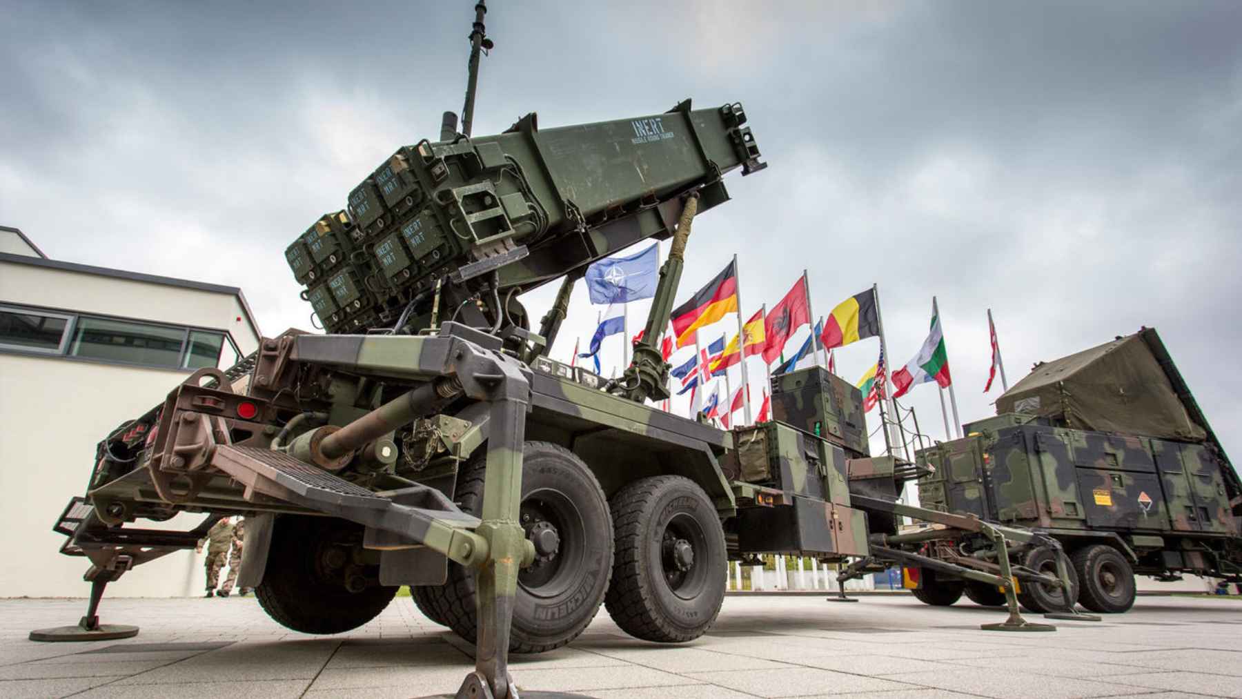 Thales unveils an anti-aircraft shield capable of detecting missiles 5,000 kilometers away and reacting in seconds 1 Mobile air defense missile launcher and radar system displayed at a NATO event with multiple national flags in the background