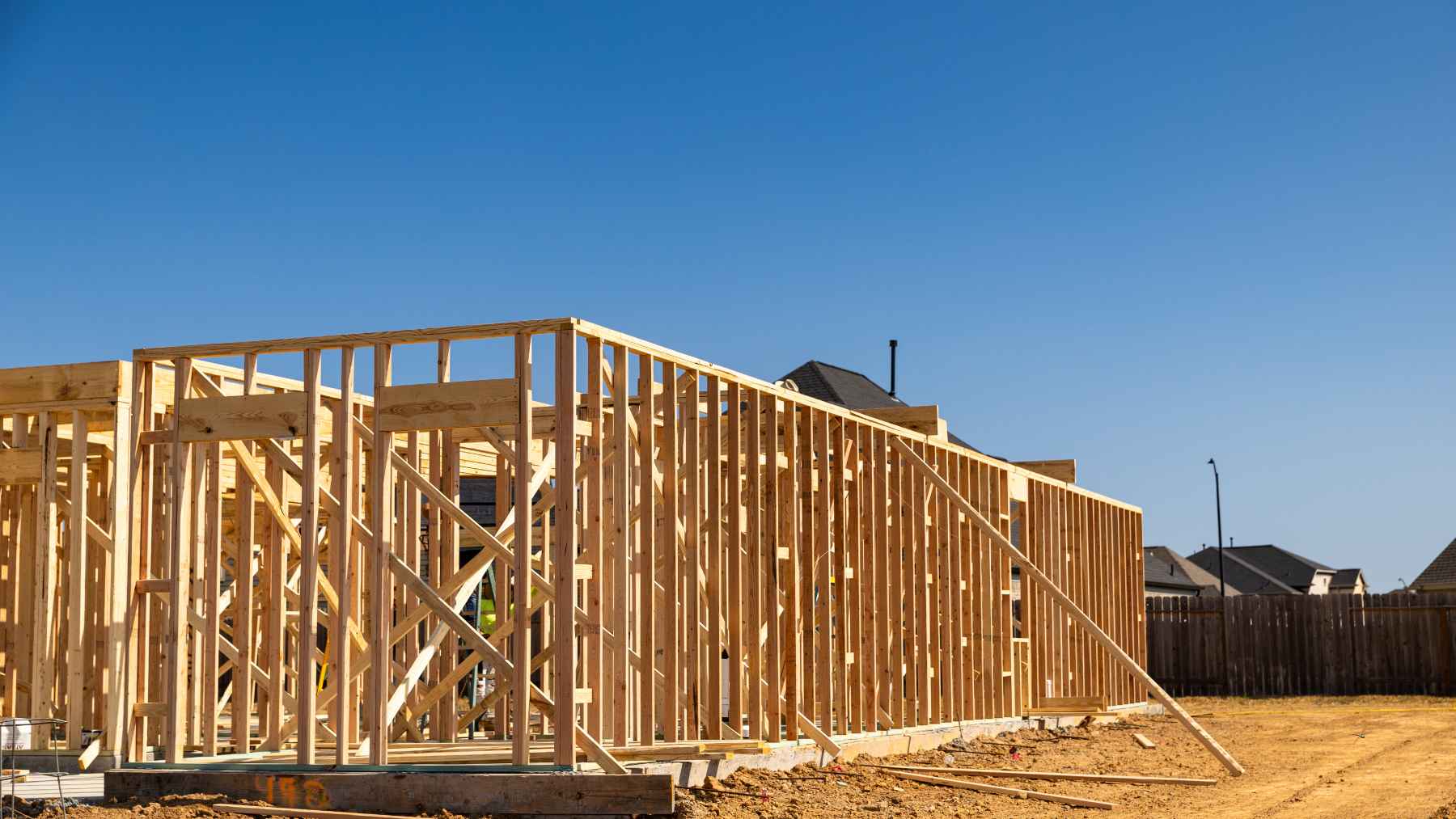 Timber-frame house under construction, showing wood framing as part of lower-emission building methods