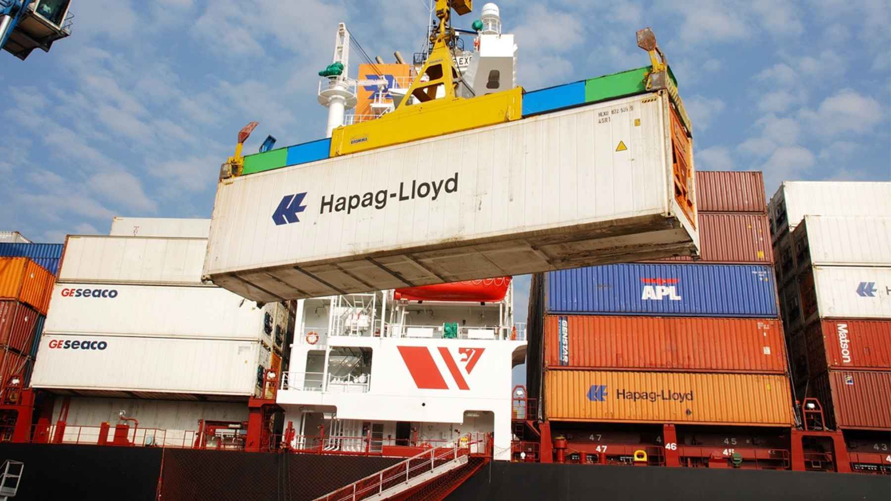 Shipping containers at a U.S. port where rising tariffs and customs bond requirements are affecting solar and energy imports.