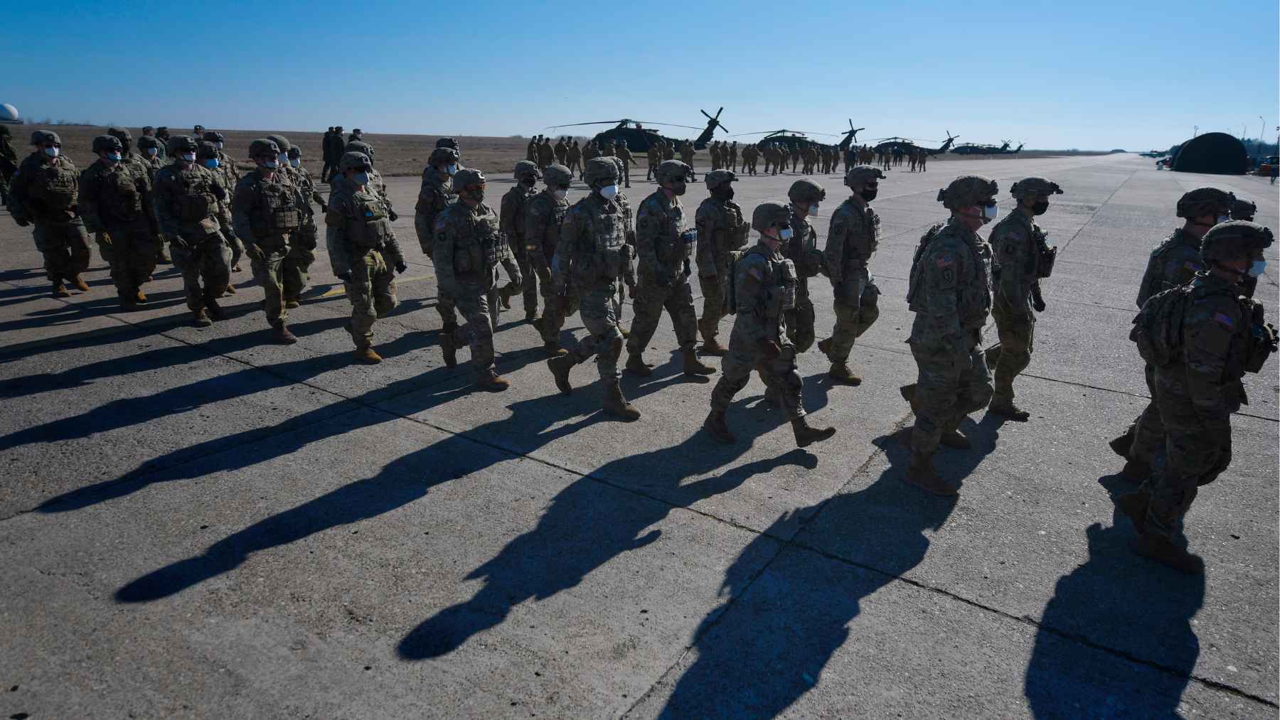 U.S. National Guard troops standing near military vehicles during a security deployment in Minneapolis amid protests.
