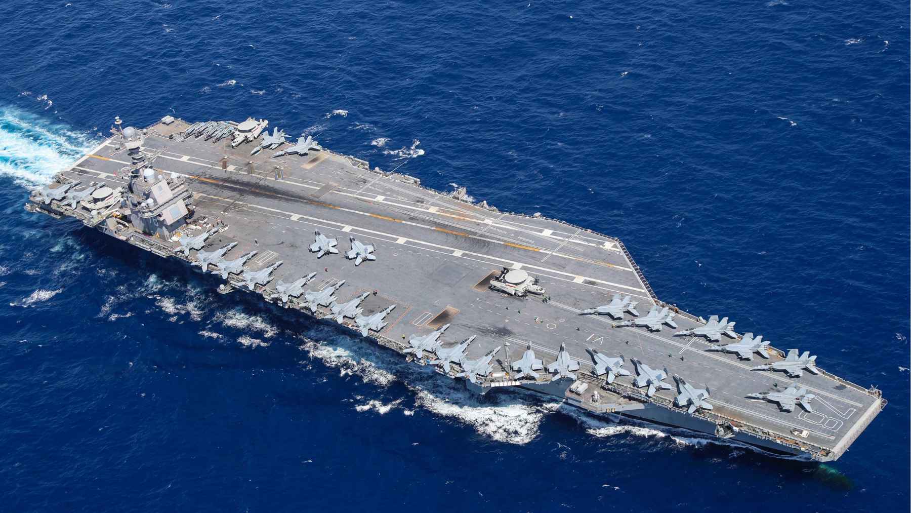 USS Gerald R. Ford aircraft carrier at sea during an extended deployment that highlights the environmental and logistical cost of modern naval power