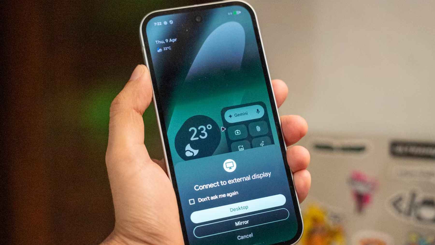 Android phone connected to a monitor showing desktop mode with multiple app windows and taskbar interface