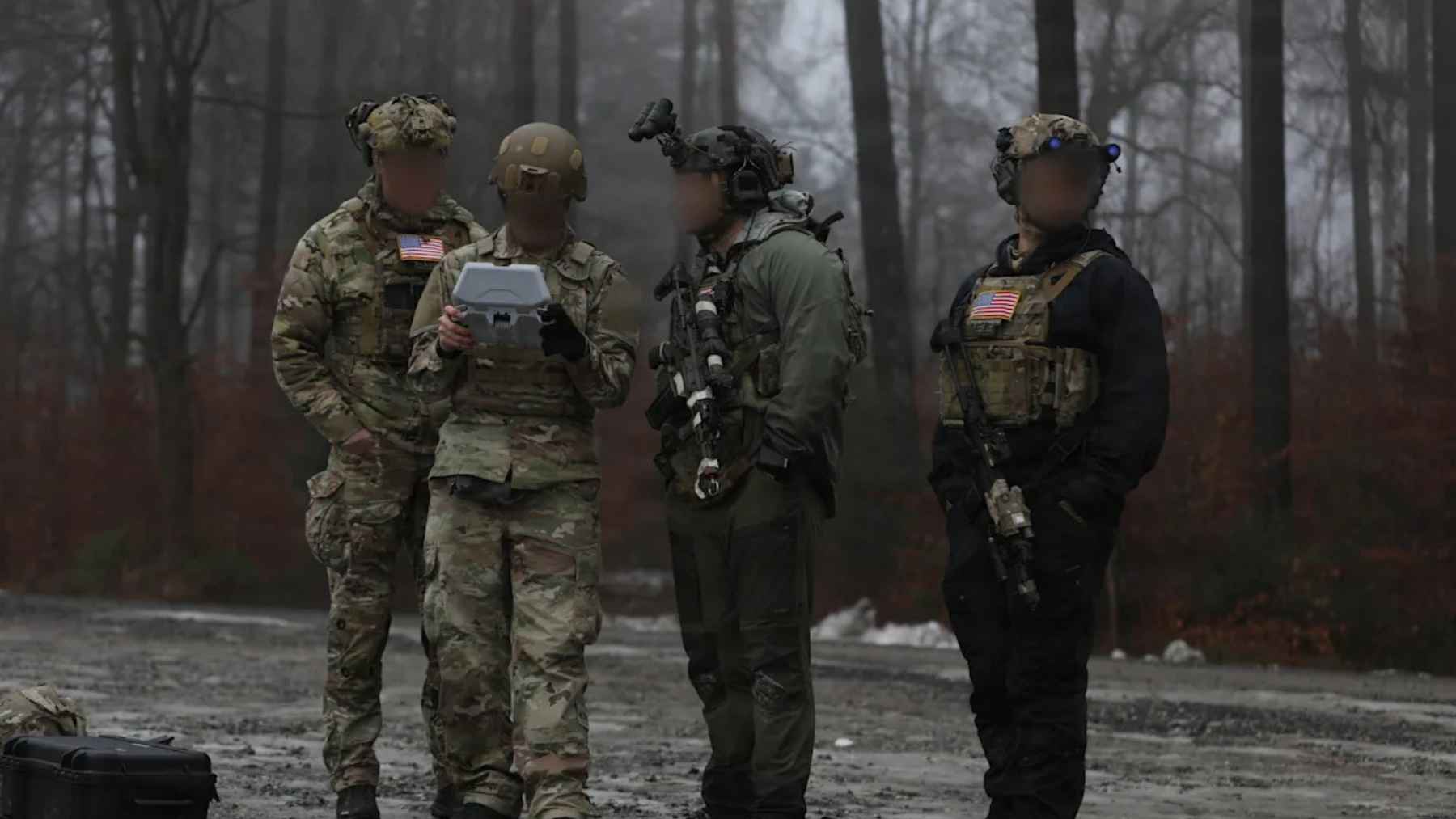 Green Berets reviewing drone data during stealth training exercise in forest environment