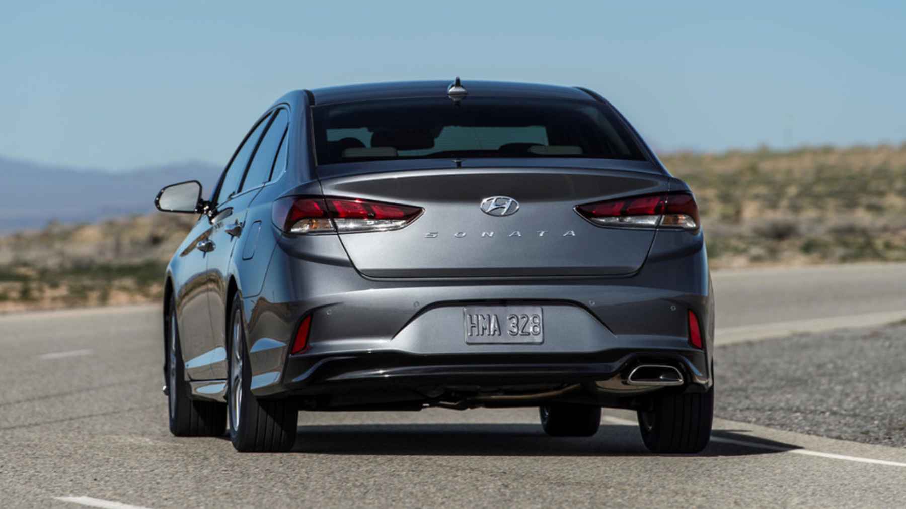 Hyundai Sonata raised on a mechanic lift during inspection showing underside and transmission area