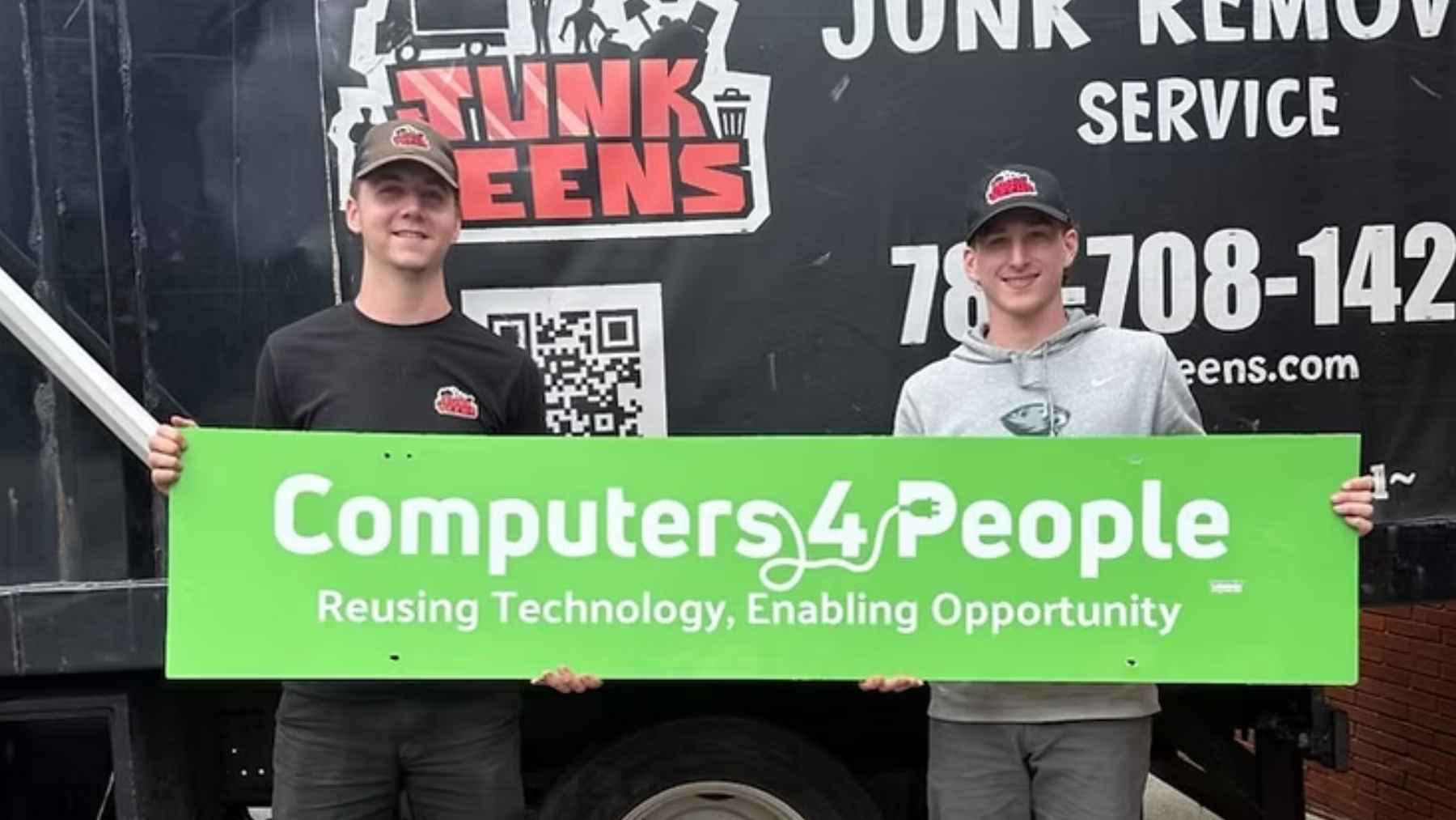 Founders Kirk and Jacob McKinney hold a "Computers 4 People" sign in front of a Junk Teens dump truck, highlighting their new e-waste reuse initiative.