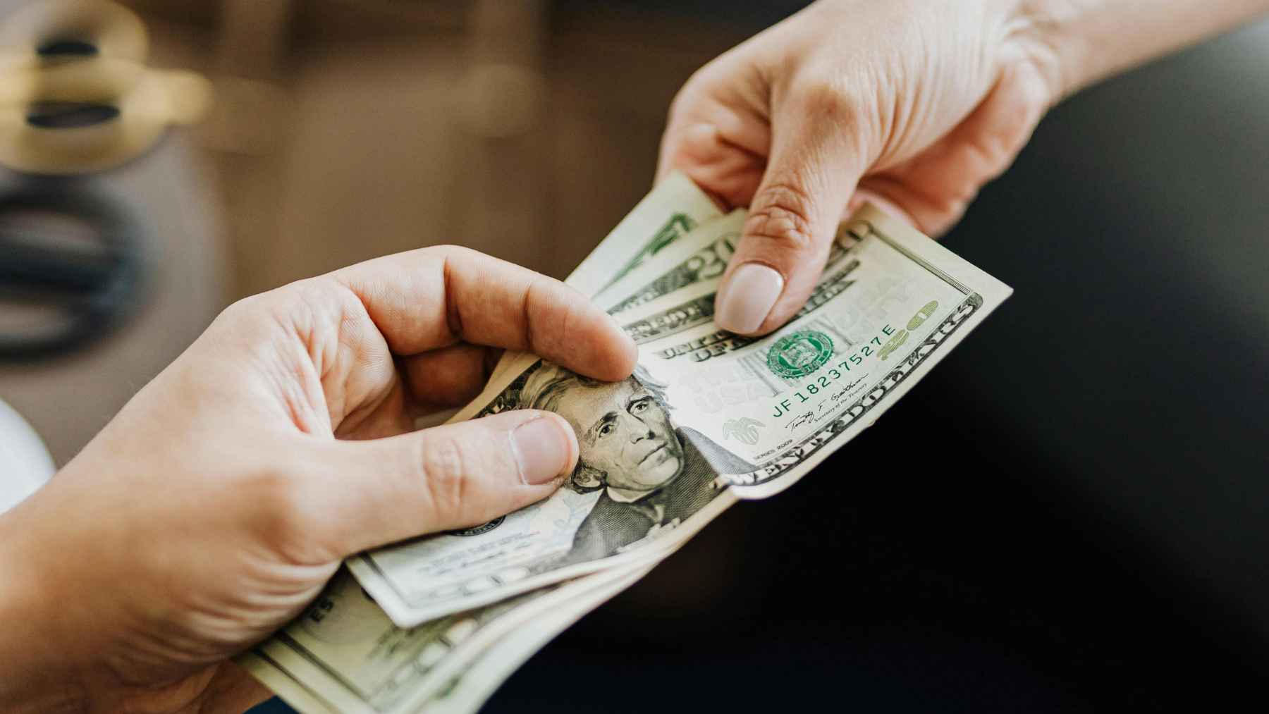 Customer paying with cash at retail store counter in New York under new law requiring businesses to accept cash