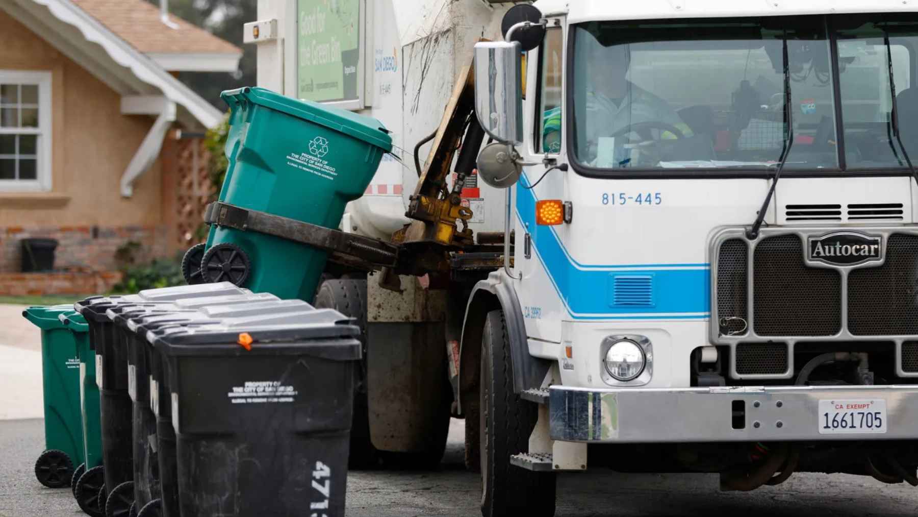 San Diego garbage truck lifting a recycling bin during curbside collection in a residential neighborhood