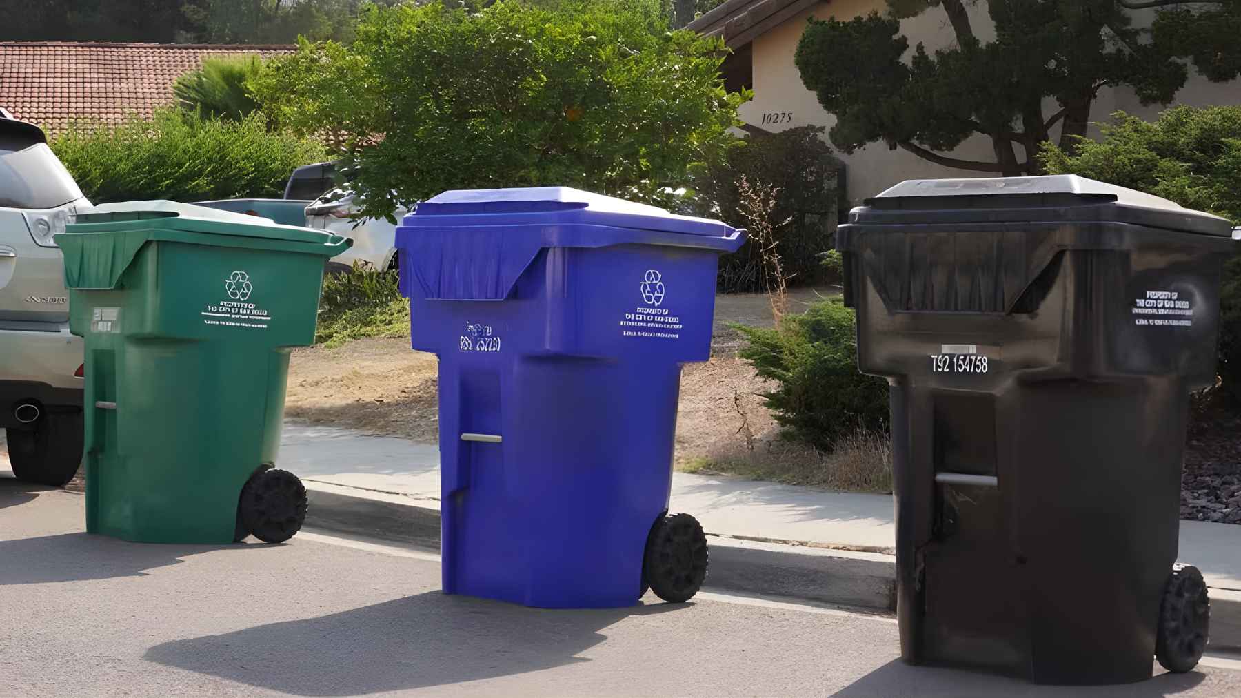 Light-blue recycling bins lined up on a San Diego street as part of the city’s new tracked waste collection program