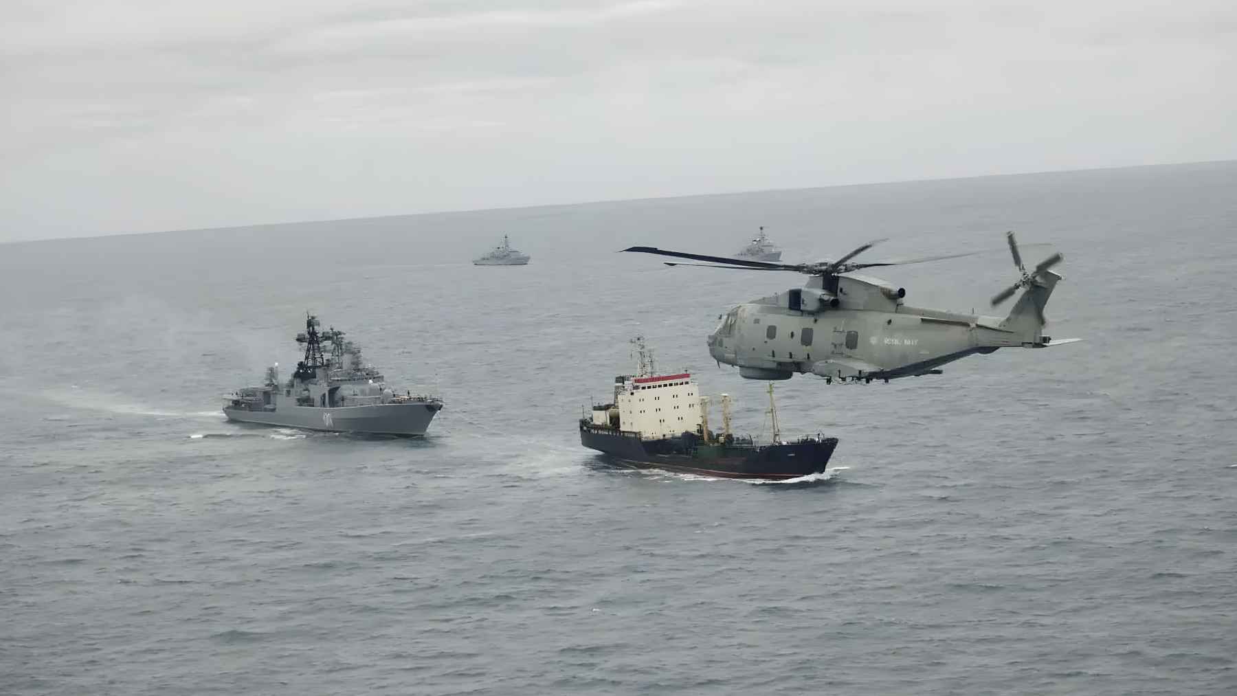 Royal Navy helicopter monitoring Russian naval vessels and cargo ship in the North Sea during a tracking operation