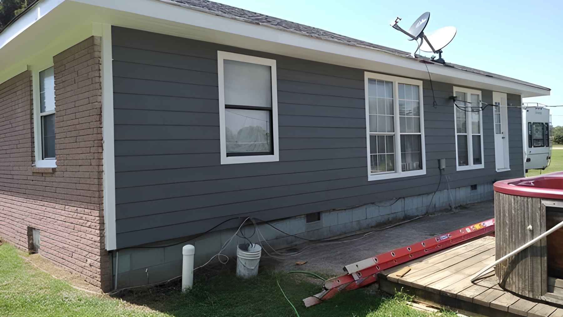 Single-story house with unfinished exterior work and visible signs of incomplete renovation projec