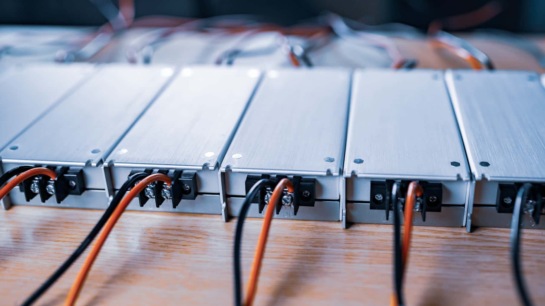 Módulos de baterías industriales conectados mediante cableado eléctrico sobre una superficie de trabajo.
