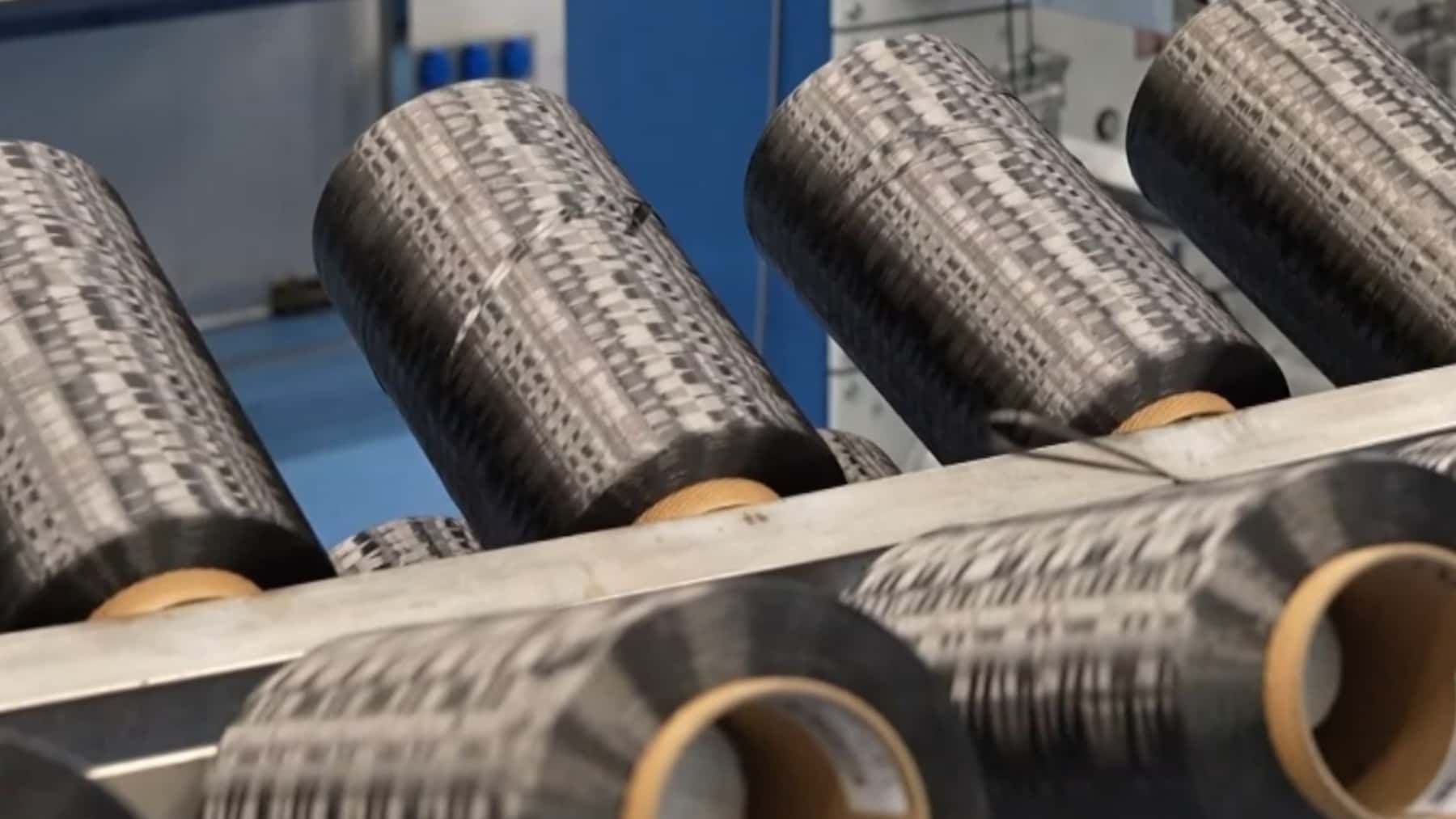 Bobinas de fibra de carbono en una línea de producción industrial.