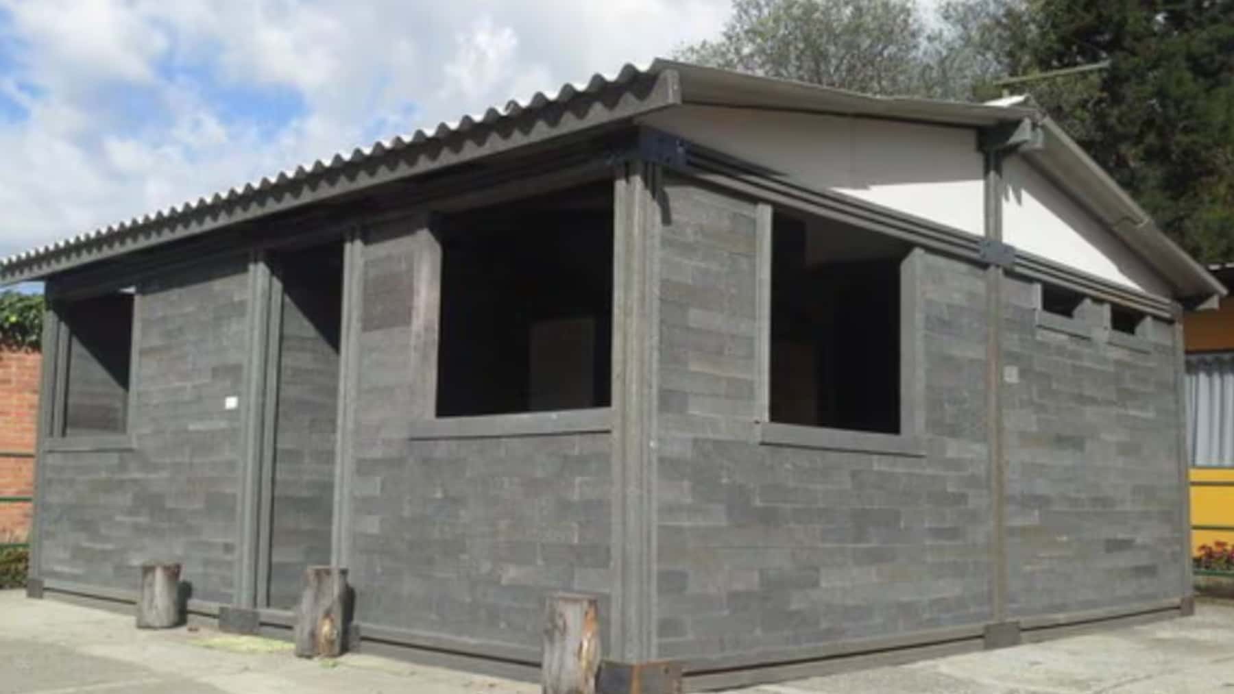 Casa modular construida con sistema de ladrillos grises y cubierta inclinada.