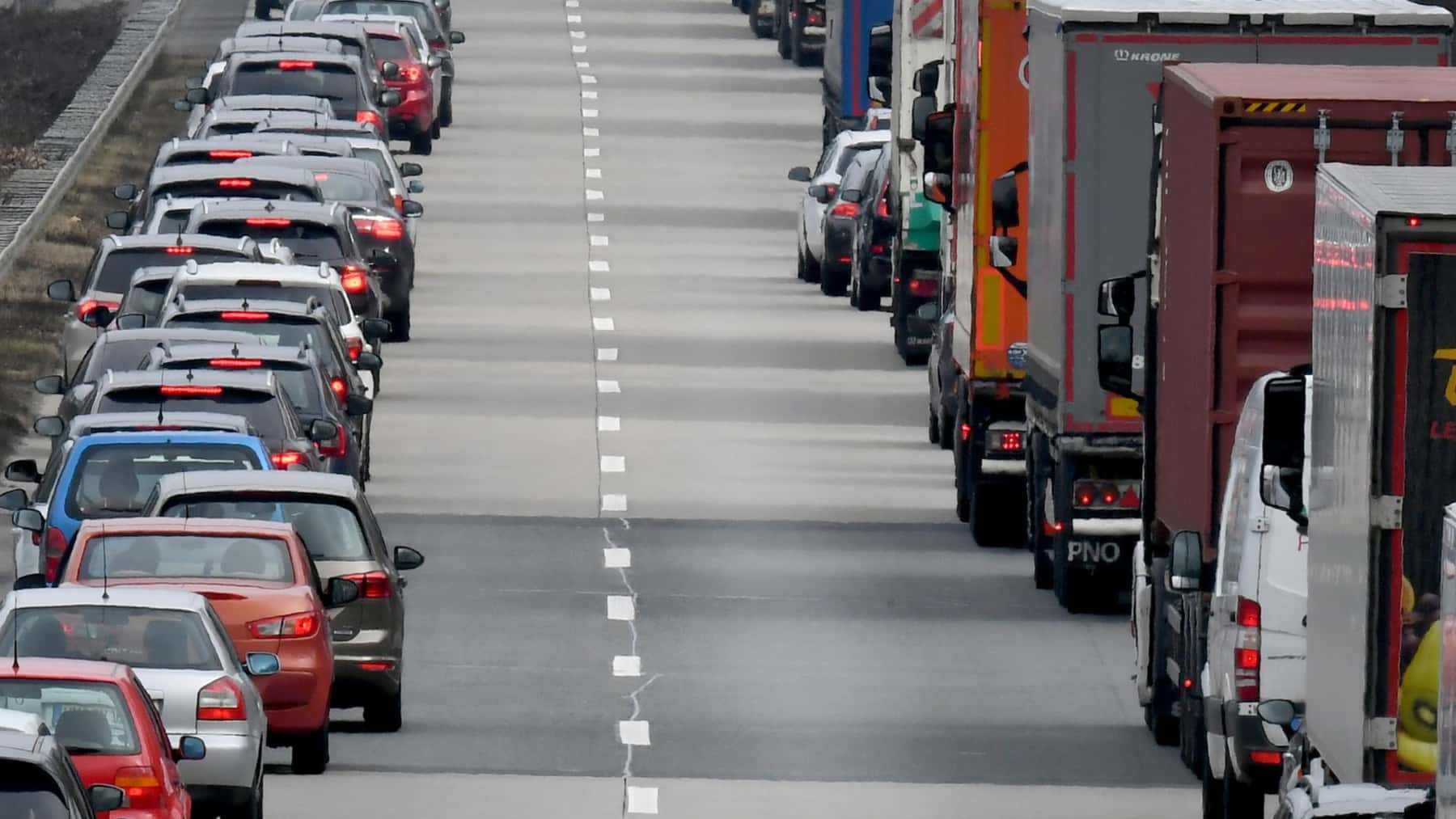 Coches y camiones circulan por una autopista dejando libre el carril central.