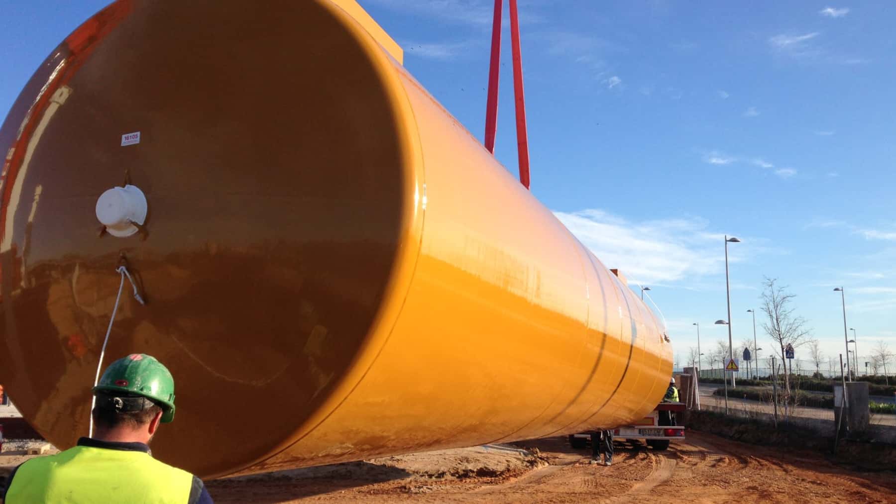 Gran depósito cilíndrico de una desalinizadora siendo instalado en una obra industrial.