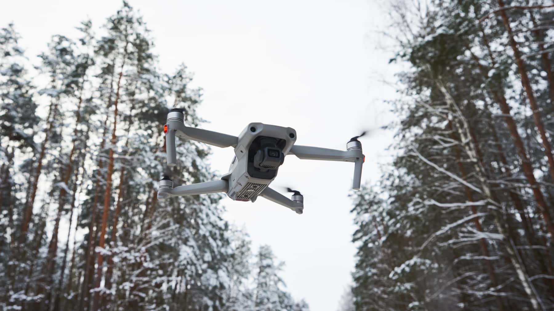 Dron volando sobre un bosque nevado durante el invierno.