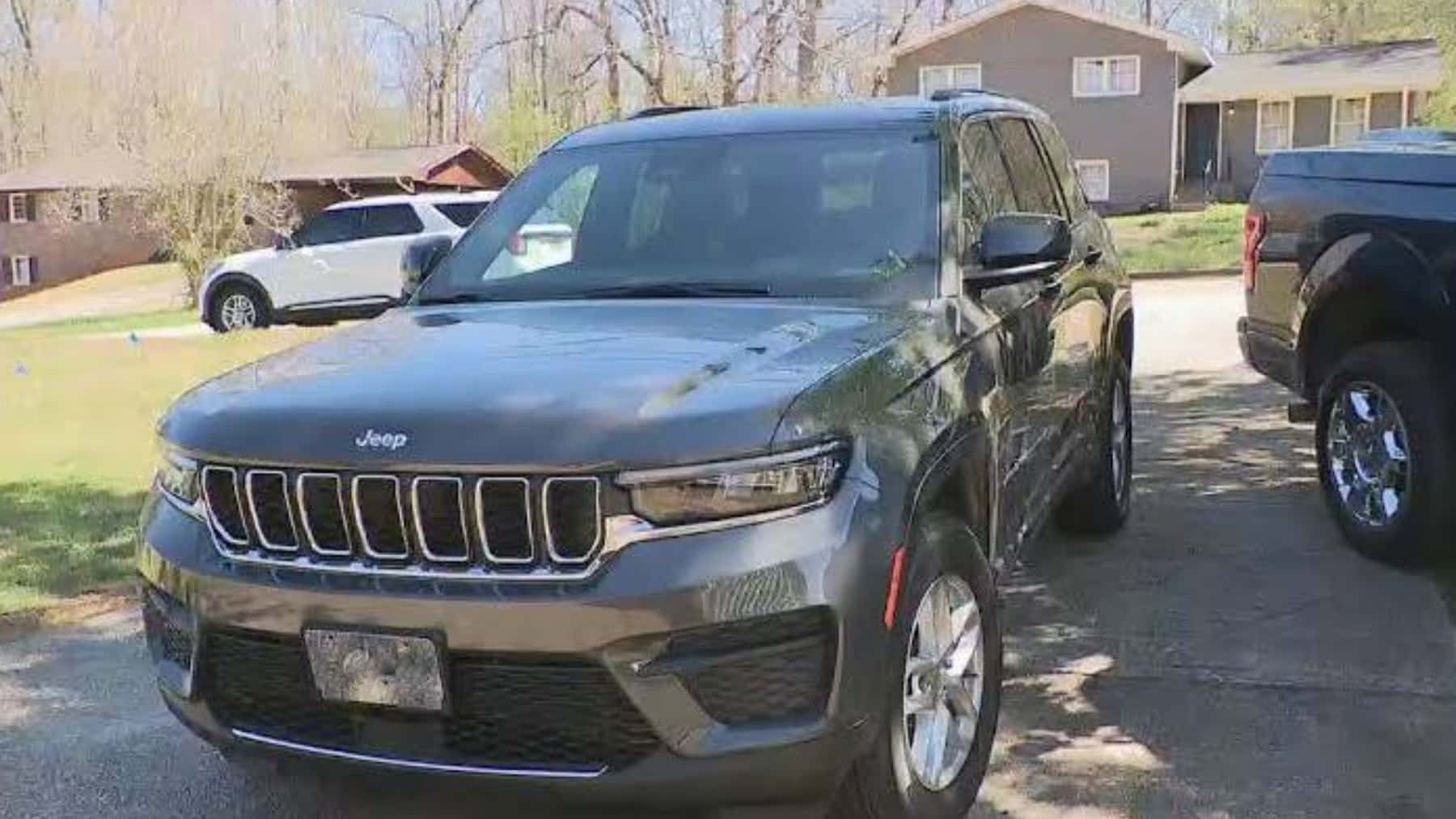 Vehículo Jeep SUV gris aparcado en la entrada de una vivienda
