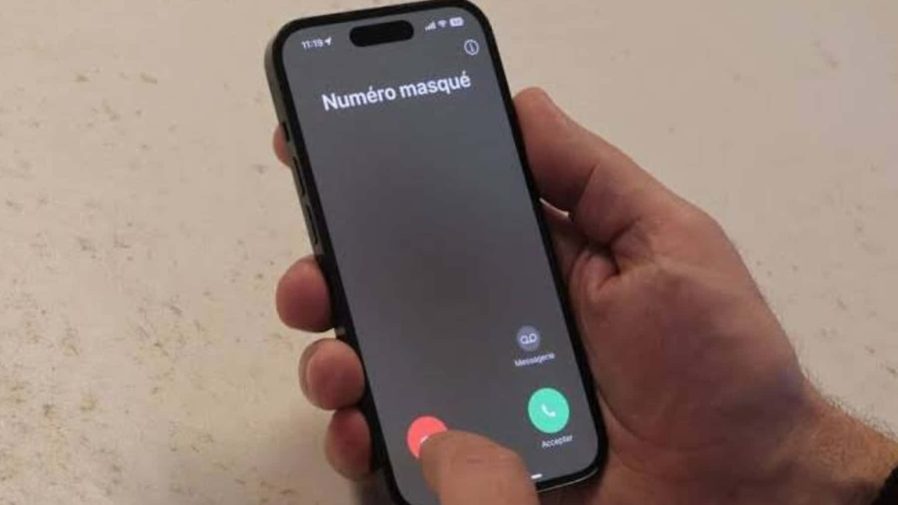 Persona rechazando una llamada de número oculto en la pantalla de un teléfono móvil.