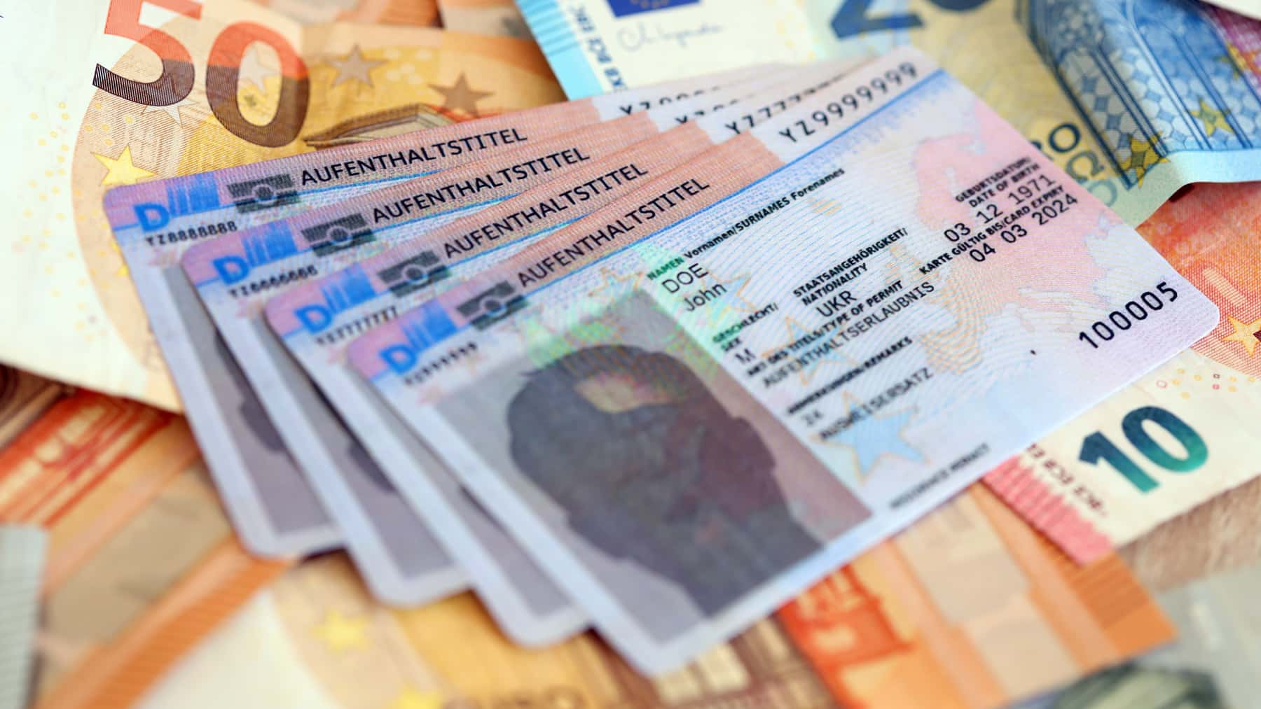 Varios permisos de residencia de Alemania colocados sobre billetes de euro