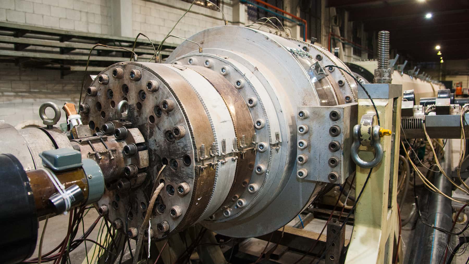 Reactor de fusión nuclear con tuberías y componentes técnicos en una instalación de laboratorio.