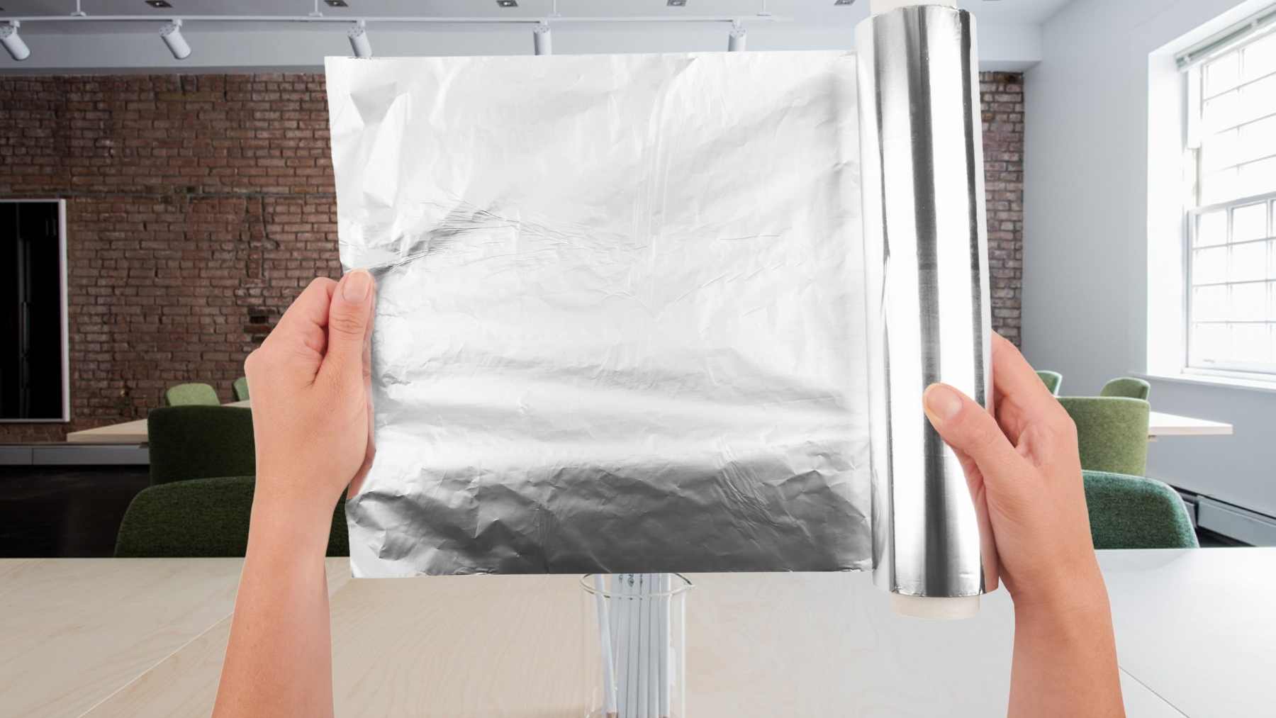 Manos sujetando papel de aluminio y rollo para hacer la prueba que detecta humedad en la pared en 24 a 48 horas.