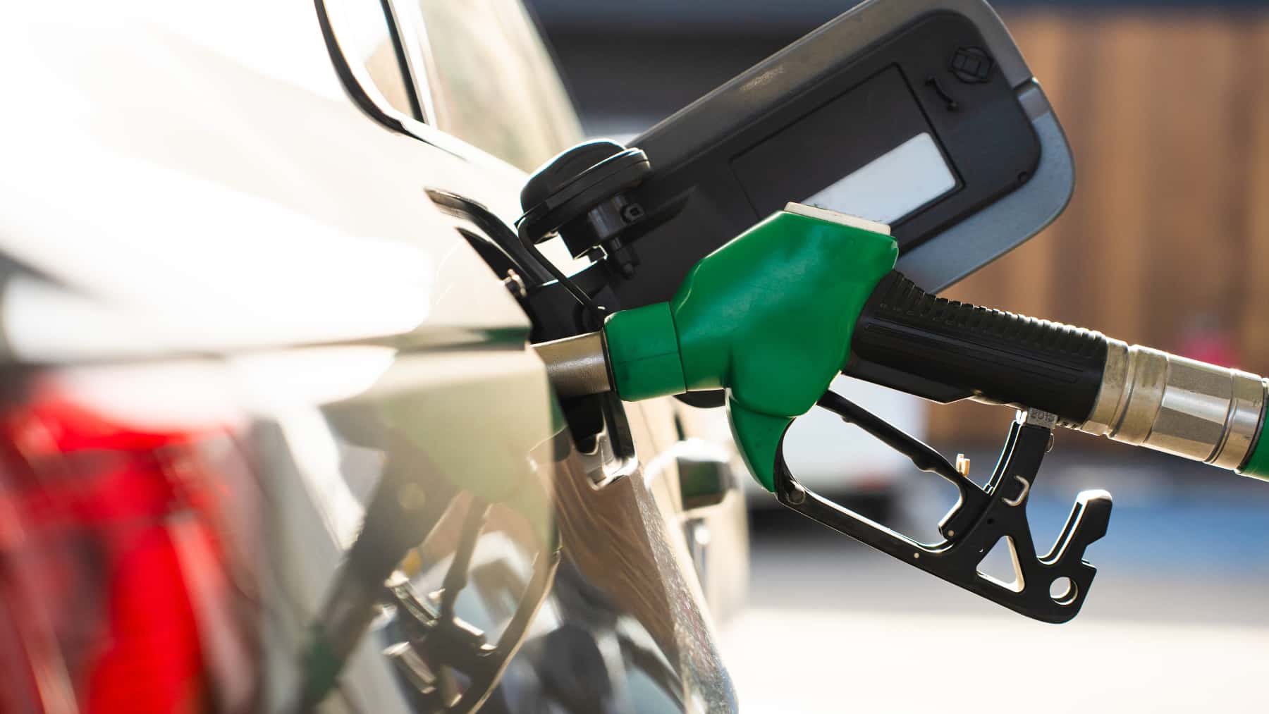 Primer plano de la boquilla de combustible de gasolina en el tanque de combustible del automóvil