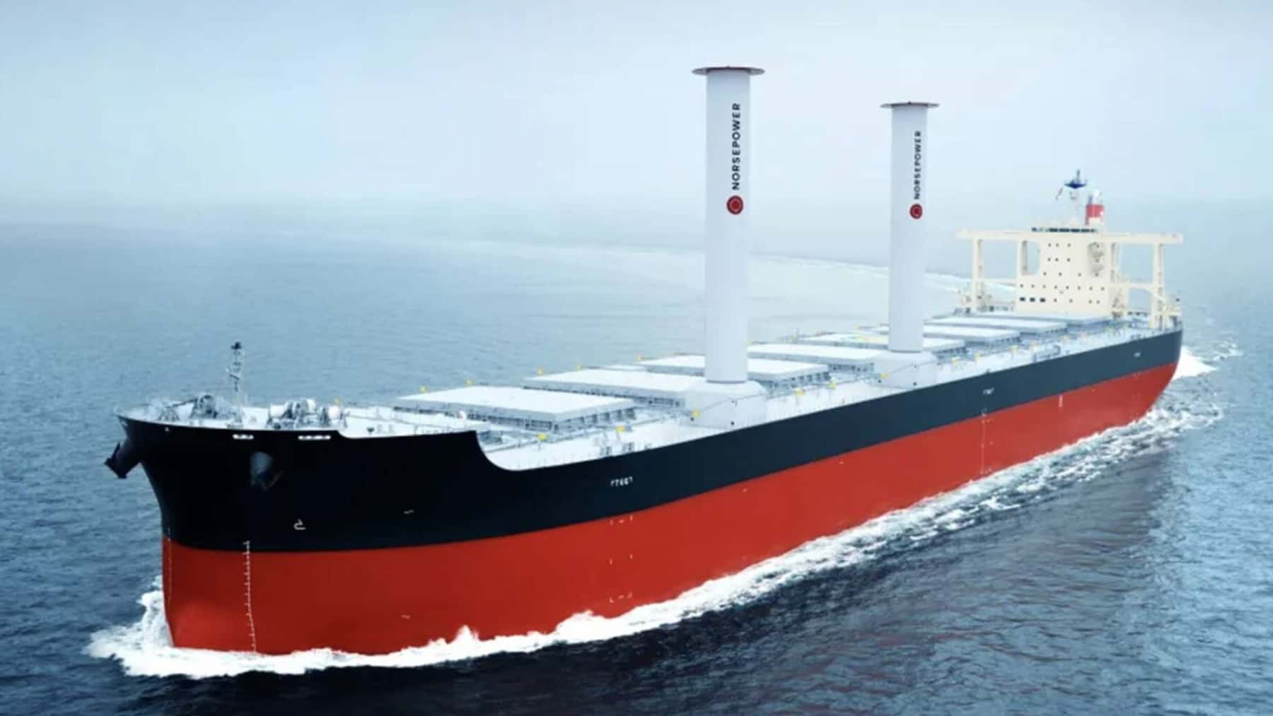 Buque carguero navegando en el mar con dos velas rígidas Norsepower instaladas en la cubierta para reducir el consumo de combustible.