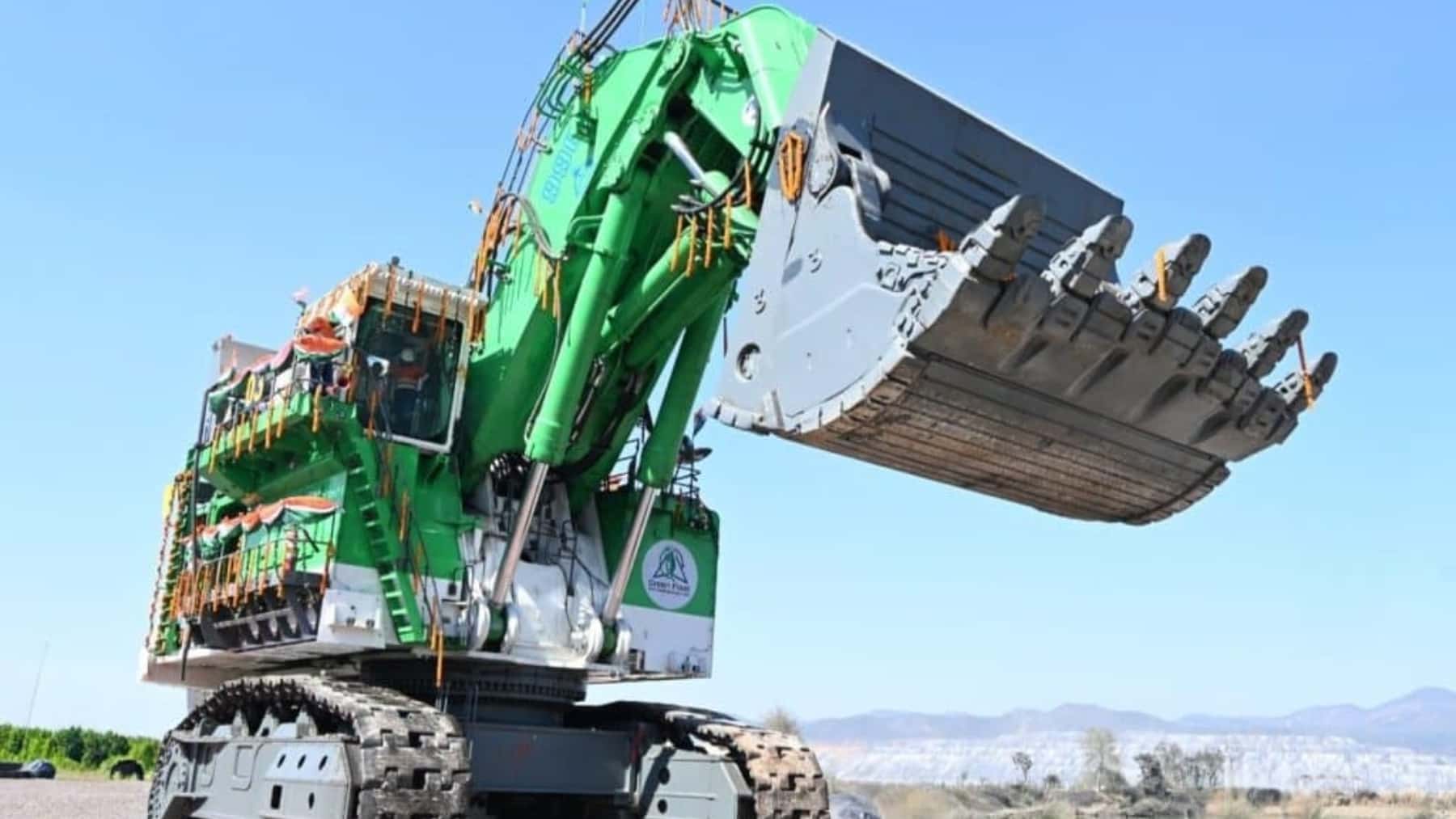 Excavadora minera eléctrica de gran tamaño con brazo hidráulico y cuchara elevada en una explotación a cielo abierto.