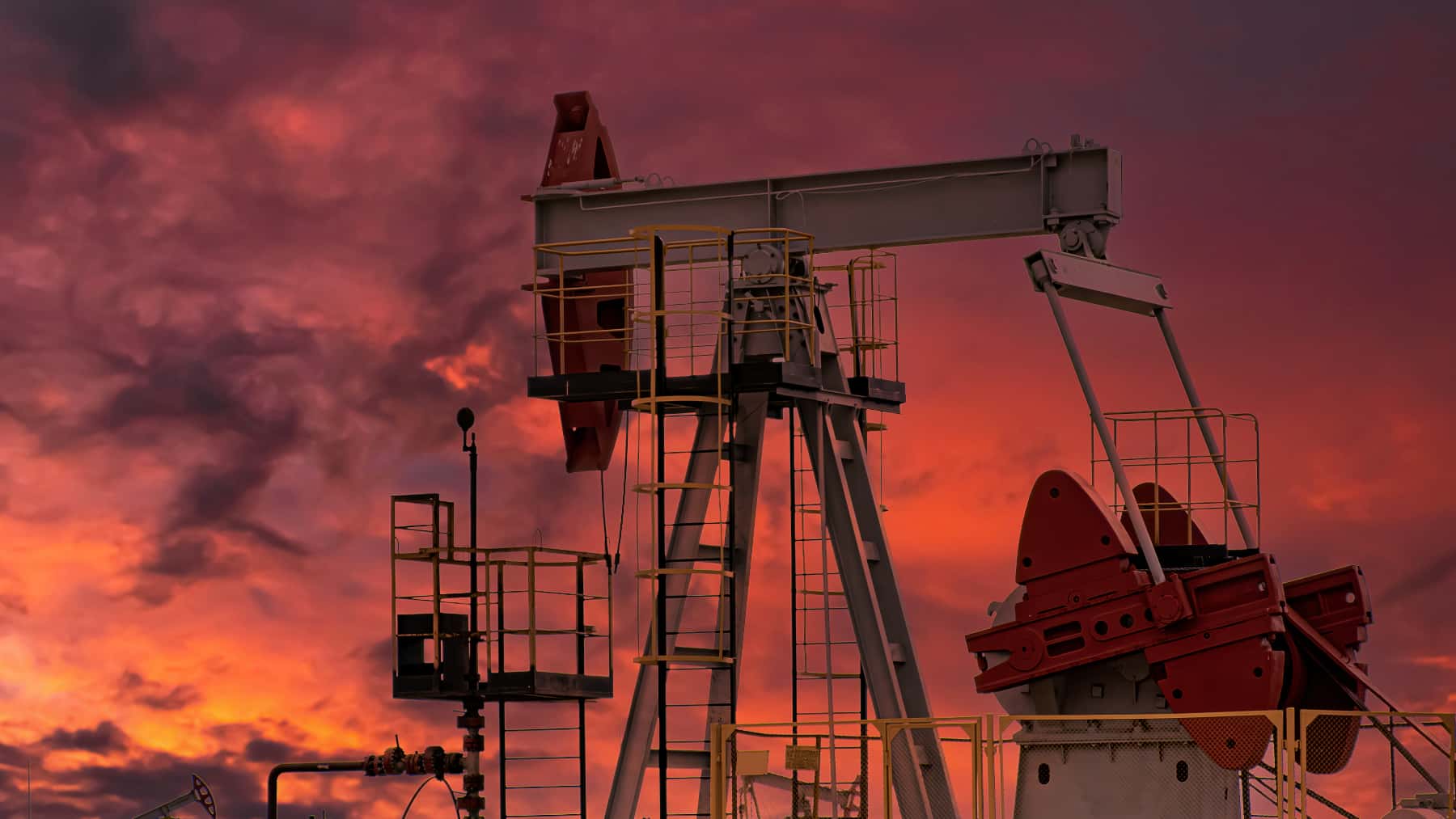 Plataforma de perforación petrolera y conector de bomba en el fondo del atardecer