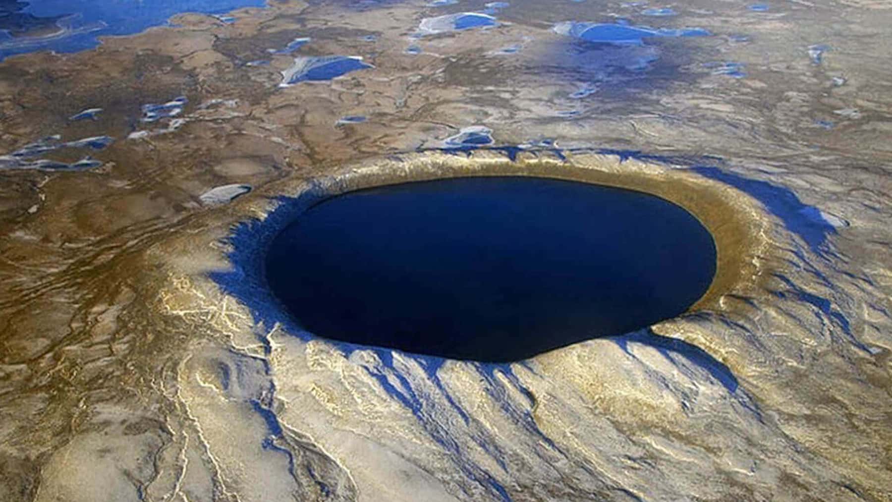 Vista aérea de un gran lago circular formado en un cráter o socavón en una zona árida de Turquía.