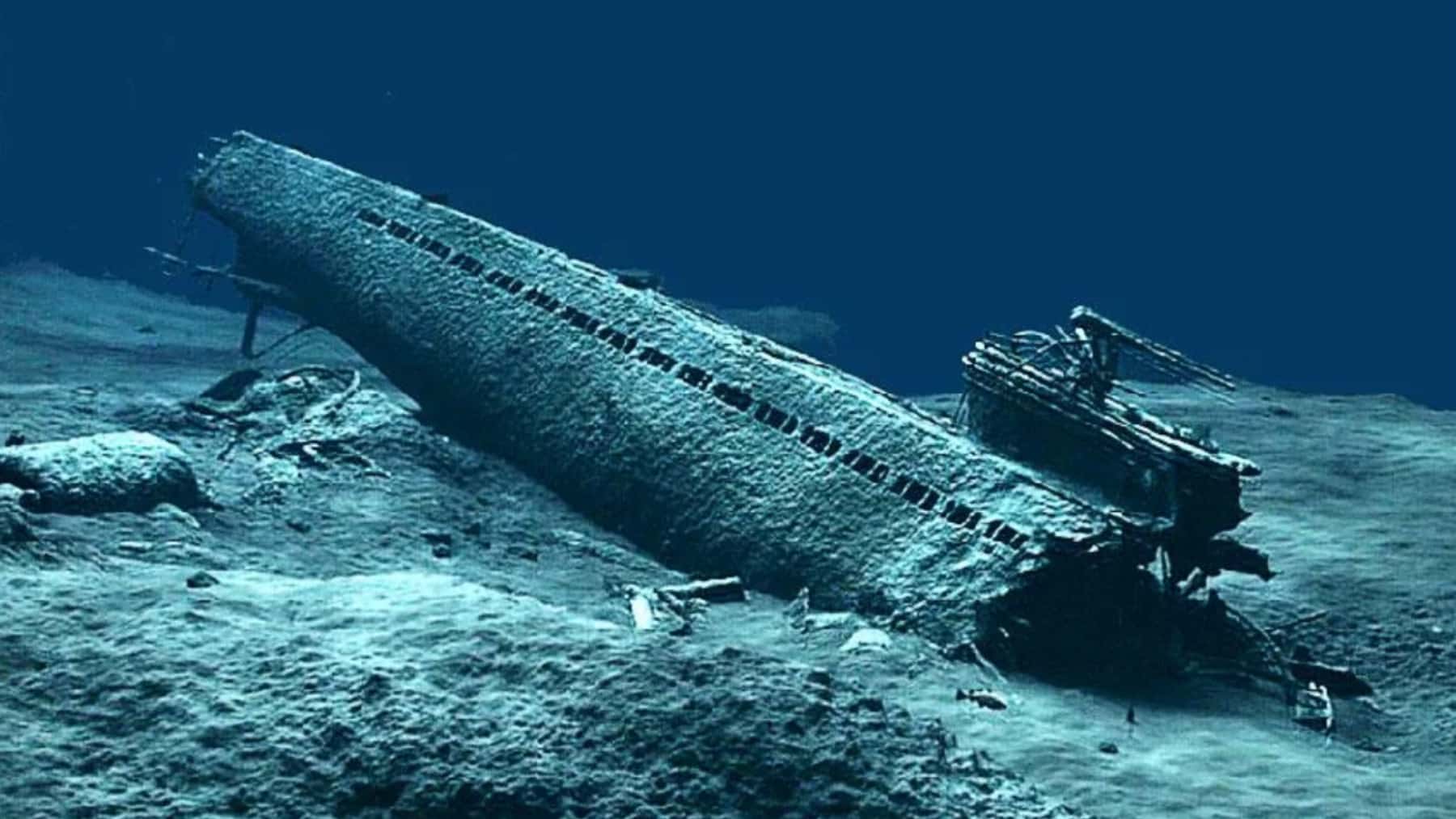 Submarino hundido en el fondo del mar rodeado de restos bajo el agua.